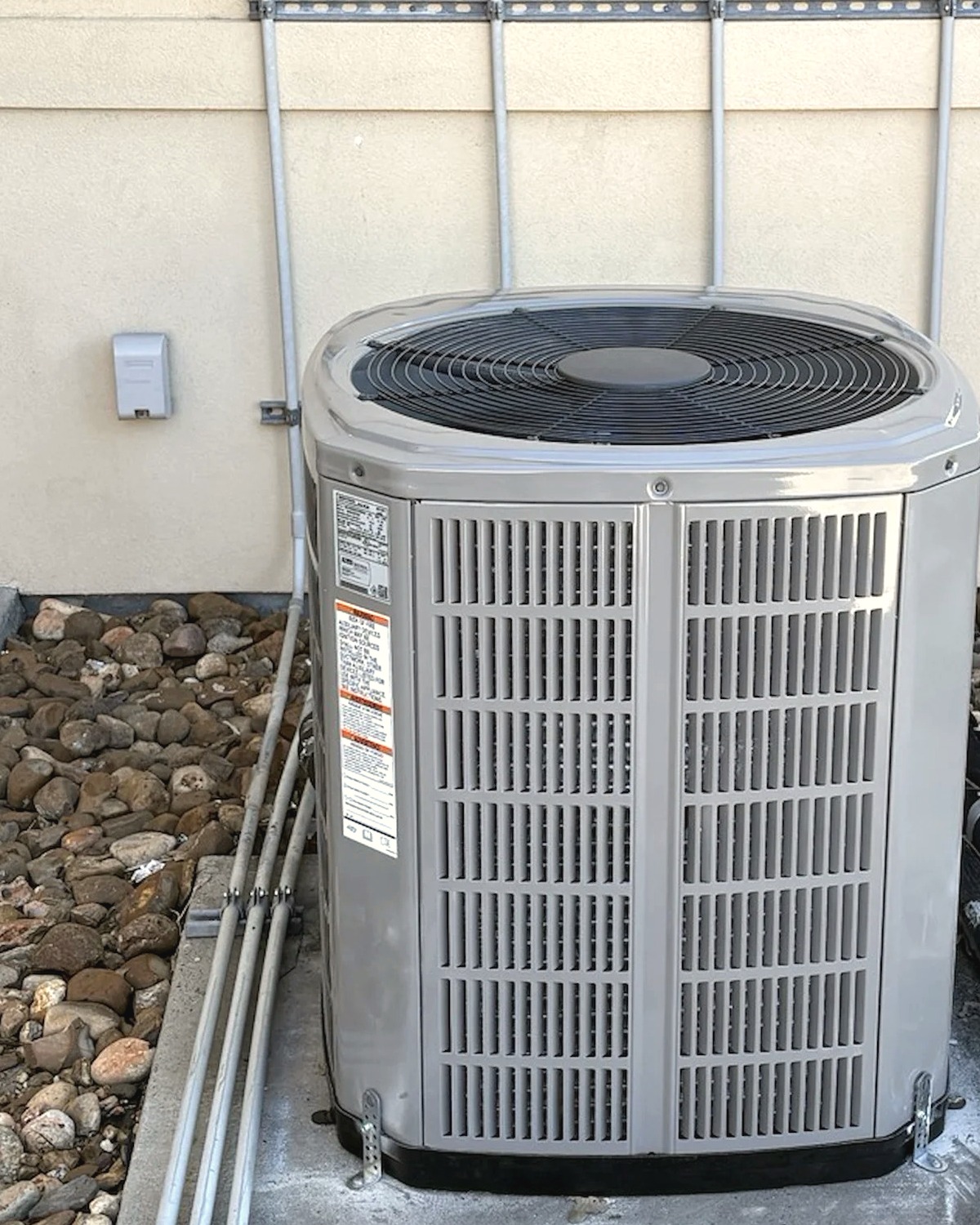 New American Standard outdoor unit on a concrete pad, with four disconnects on a rail above it, at a Corpus Christi home